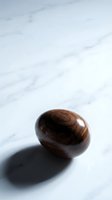 Polished wooden egg with rich grain texture casting shadow on white marble surface for minimalist decor and natural design concepts.