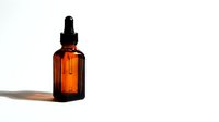 Amber glass dropper bottle with essential oil or serum on white background, suitable for cosmetics, skincare, wellness, and pharmaceutical product packaging design and marketing.