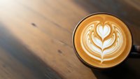 Coffee cup with heart latte art on wooden table, barista crafted cappuccino with milk foam design for cafe menu, morning beverage and coffee shop atmosphere.