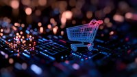 Shopping cart on computer keyboard with glowing circuit patterns and bokeh lights, representing digital commerce and online retail technology in modern marketplace.