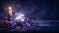 Glowing crystal ball with candle, amethyst crystals and lavender on dark wooden table, mystic smoke atmosphere for fortune telling.