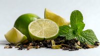 Fresh lime slices with whole fruit, mint leaves, and loose tea leaves on white background for beverage preparation or culinary use.