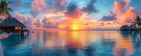 Panoramic view of overwater bungalows at sunset with vibrant orange clouds reflecting in calm turquoise lagoon waters, tropical palm trees frame luxurious resort scene.