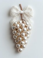 Elegant pearl grape cluster ornament with white lace bow on neutral background for wedding decor and luxury home styling projects.