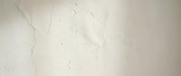 Cracked white plaster wall texture with fine lines and weathered surface, suitable for backgrounds, overlays, and architectural design projects.