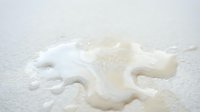 Fresh milk splash creating dynamic crown shape with droplets on white surface for dairy advertising and beverage marketing campaigns.