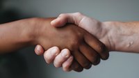 Two people with different skin tones shaking hands in a gesture of agreement, partnership, or business deal. Suitable for corporate, diversity, teamwork, and professional collaboration concepts.