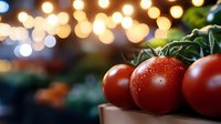 Fresh ripe tomatoes on vine with water drops against blurred bokeh lights background, creating cozy atmosphere for food photography and menu design.