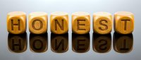 Wooden letter blocks spelling HONEST with mirror reflection on glossy surface. Business ethics and integrity concept for corporate presentations.