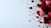 Red glittery heart shapes scattered on white background with copy space, creating romantic Valentine's Day composition for greeting cards and social media posts.