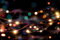 Glowing string lights with colorful bokeh effect on dark background create magical atmosphere for festive holiday designs and celebrations.