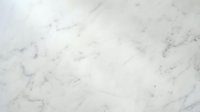 White marble surface with natural gray veining patterns and subtle texture variations for luxury interior design and architectural applications.