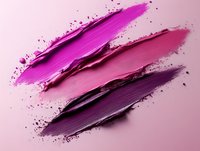 Vibrant smeared cosmetic powder swatches in shades of pink and purple against soft pink background, showcasing makeup texture and pigmentation for beauty industry use.