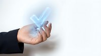 Businesswoman holding glowing checkmark symbol, representing approval, success, and quality assurance in corporate environments and digital transactions.
