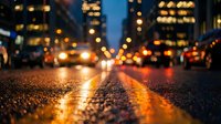 Wet city street at night with glowing bokeh lights, cars, and reflections on asphalt, low-angle urban traffic scene.