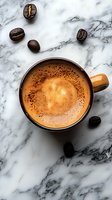 Fresh cup of creamy coffee with frothy crema and scattered roasted coffee beans on luxurious white marble surface, captured from above in natural light.