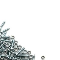 Metal screws, bolts, nuts and washers scattered on white background for construction and repair projects.
