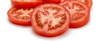 Fresh red tomato slices showing seeds and pulp isolated on white background for cooking, salad preparation and healthy food concepts.