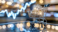 Shopping cart with ice cubes on reflective surface against blurred stock market chart and bokeh lights background, representing consumer market trends.