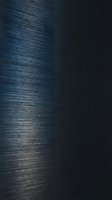 Brushed metal surface with fine linear texture and dark background, suitable for industrial design, technology backgrounds, and modern graphic projects.