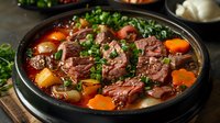 Traditional beef stew with tender meat chunks, carrots and fresh herbs in black ceramic pot, perfect for restaurant menu, food photography and seasonal comfort food recipes.