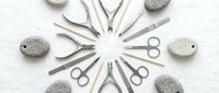 Professional manicure and pedicure tools arranged in circular pattern with pumice stones on white background for beauty salon and nail care services.