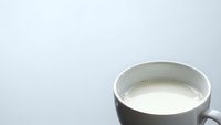 Fresh milk in ceramic cup on clean white background for healthy breakfast and dairy product advertising campaigns.
