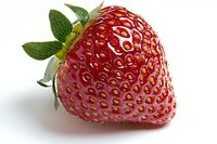 Fresh ripe strawberry with green leaves isolated on white background, macro shot showing detailed texture and seeds, for food packaging and advertising.
