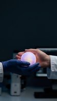 Two professionals in lab coats and gloves holding a glowing orb, symbolizing innovation, technology transfer, and scientific collaboration in research and development environments.