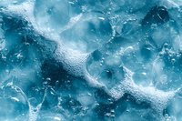 Frozen ice texture with air bubbles trapped beneath surface creates abstract winter pattern in turquoise blue tones. Natural crystalline formation background.