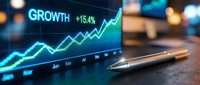 Financial growth chart displaying upward trending data with glowing blue analytics on digital screen alongside golden pen for business planning and investment.