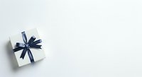 White gift box with navy blue ribbon bow on white background, isolated and ready for holiday, celebration, and promotional design use.