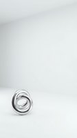 Modern silver metallic spiral ring sculpture on white background with copy space for contemporary design projects.
