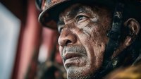Weathered senior African American firefighter with dirt-covered face gazing intensely, showcasing bravery and dedication in emergency services profession.