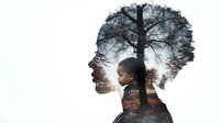 Double exposure portrait combining African American woman's profile with silhouette of bare tree against moody sunset sky, creating contemplative nature connection.