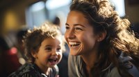 Young mixed race mother and daughter share joyful laughter moment together, genuine emotional connection captured in warm natural lighting. Family bonding scene.
