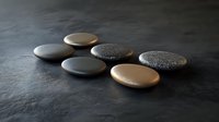 Smooth spa stones arranged in curved line on dark textured surface with dramatic side lighting creating zen atmosphere for wellness and relaxation concept.