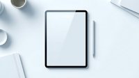 Modern tablet with blank white screen and stylus on clean white desk workspace with coffee cup and office supplies for digital design mockup.