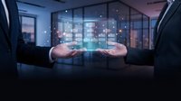 Businessman in dark suit holding glowing digital network interface with connected nodes and data visualization above hands in modern office environment.