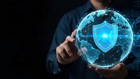 Businessman holding holographic globe with glowing security shield symbol representing global cybersecurity and data protection technology solutions.