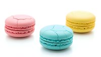 Colorful French macarons with cracked shells in pink, blue and yellow on white background. Sweet pastry dessert cookies isolated for bakery design.