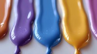 Colorful liquid paint drops flowing downward in vibrant purple, blue, yellow and pink hues creating artistic dripping effect on white background.