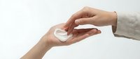 Close-up of two hands exchanging a white circular object against neutral background, isolated for design use on merchandise and promotional materials.