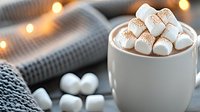 Hot chocolate topped with marshmallows in white ceramic mug, cozy winter setting with warm lights and knitted blanket, comfort food photography.