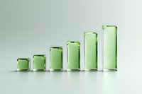 Growing green glass blocks arranged in ascending order on light background showing progression and growth concept for business presentations and data visualization.