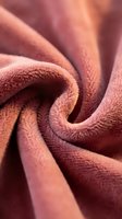 Soft coral pink microfiber fabric with twisted folds creating elegant waves and curves. Luxurious textile material for interior design and fashion projects.