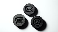 Three dark stone circular buttons featuring communication icons: envelope for mail, rotary telephone, and at symbol for email, isolated on white background for design projects.