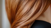 Close up view of shiny copper red hair strands flowing against dark background, showing smooth texture and natural highlights for beauty and hair care advertising.