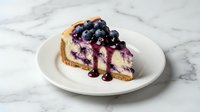 Slice of creamy blueberry cheesecake with fresh berries and syrup on white plate, marble background for dessert menu and bakery advertising.