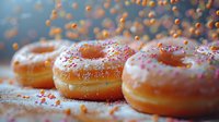 Fresh glazed donuts with colorful sprinkles on rustic surface, dynamic composition with falling sugar particles, perfect for food marketing and bakery advertising.
